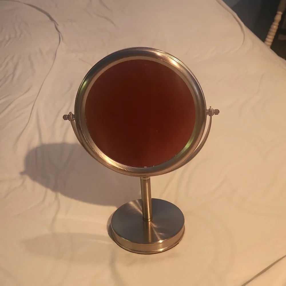 Double-sided vanity mirror, one side magnified. Silver frame